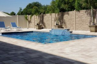 Gunite pool with a tiled sheer descent water feature and travertine deck
