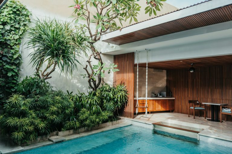 Courtyard pool beside a covered seating area with lush planting