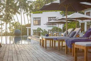 Timber pool deck with chairs and umbrellas beside a swimming pool