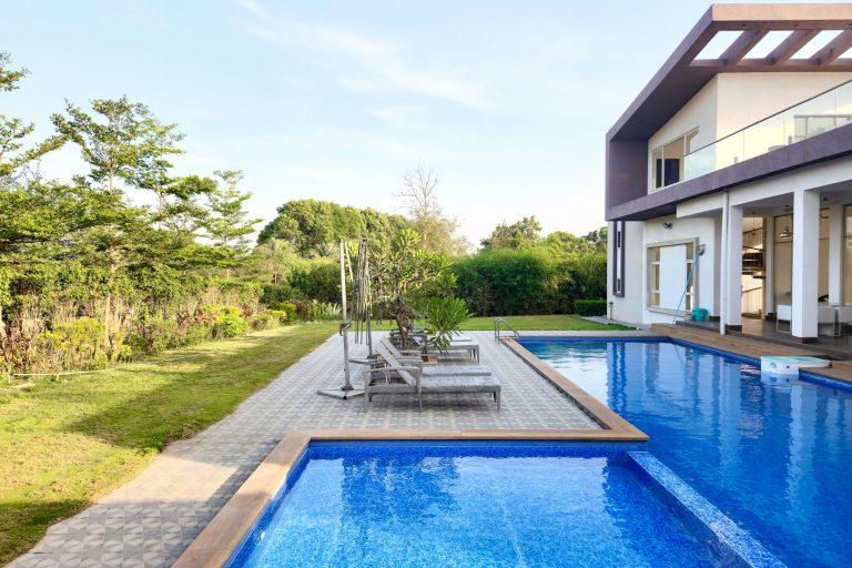 Large swimming pool built alongside a modern home
