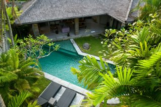 Aerial view of a home and its backyard swimming pool showing the lot layout