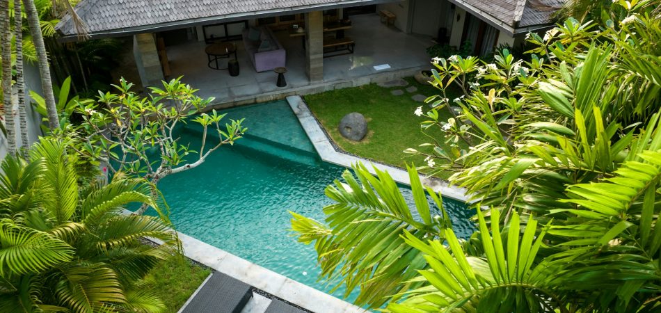 Aerial view of a home and its backyard swimming pool showing the lot layout
